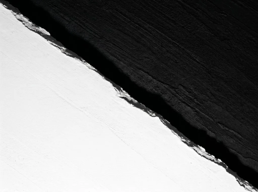 Diagonal split between black and white textured surfaces, metaphor for colour contrast
