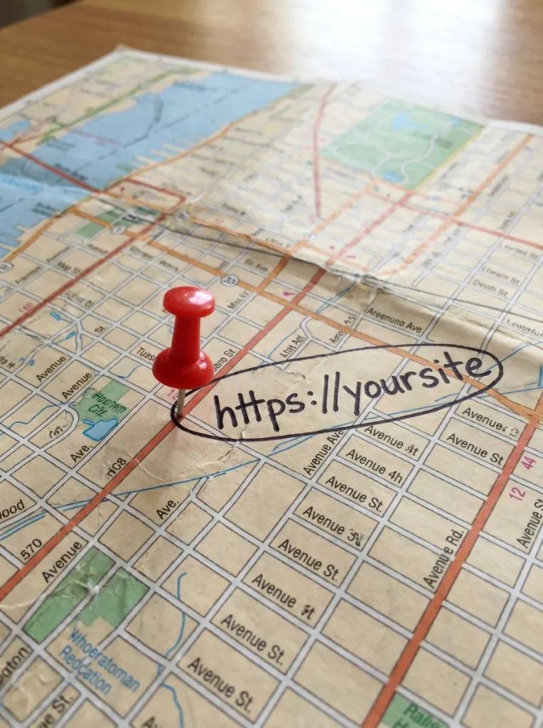 Street map with a red push pin marking a handwritten web address — local SEO visibility